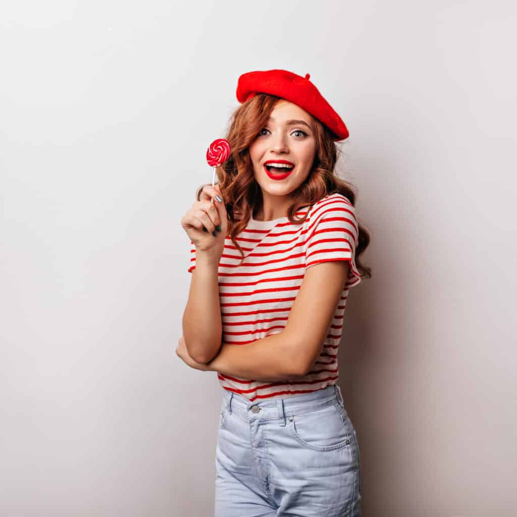 blithesome curly woman eating lollipop on white background. char